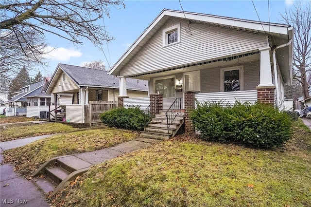 view of front of house with covered porch and a front lawn