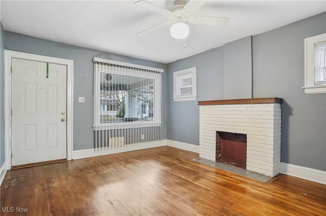 unfurnished living room featuring a fireplace, a wealth of natural light, ceiling fan, and wood-type flooring