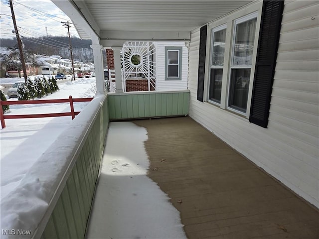 view of snow covered back of property