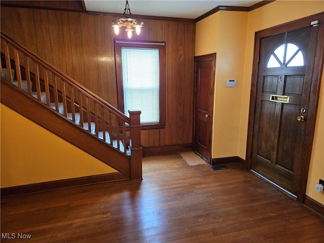 foyer featuring crown molding, a chandelier, and dark hardwood / wood-style floors