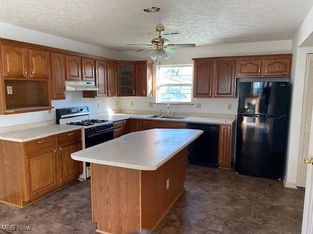 kitchen featuring dark floors, a ceiling fan, black appliances, under cabinet range hood, and a sink