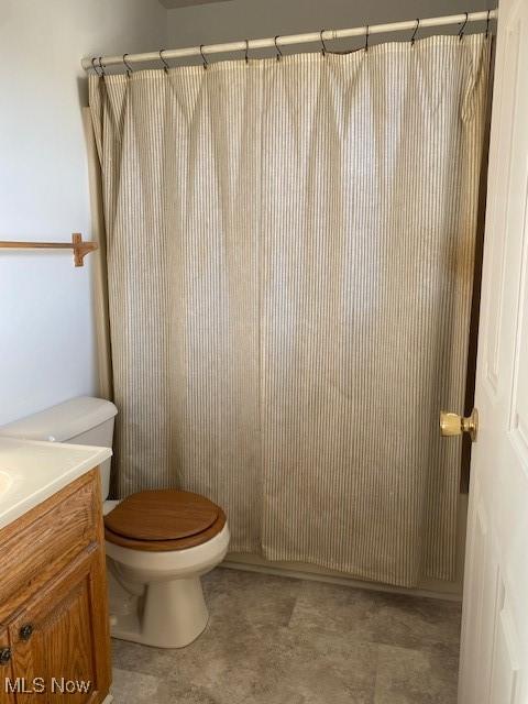 bathroom with toilet, vanity, and a shower with curtain