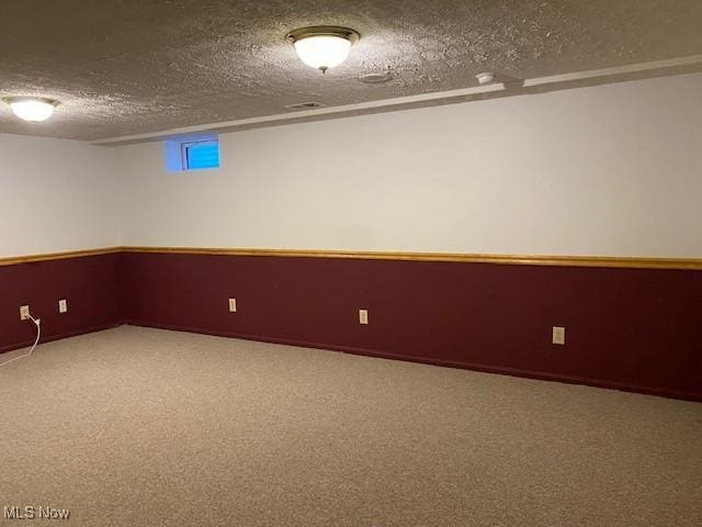 basement featuring carpet and a textured ceiling
