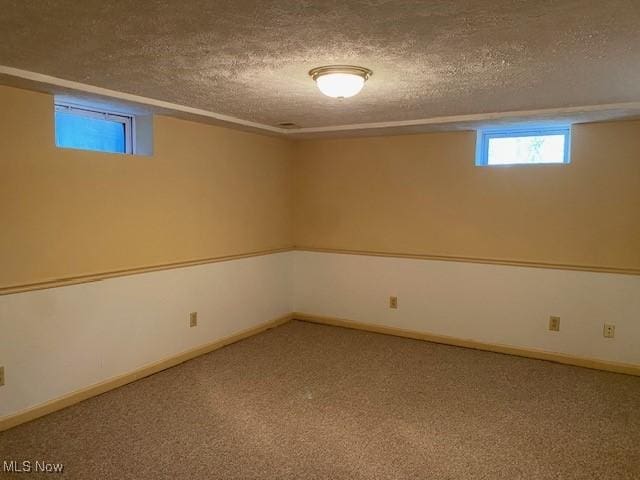 below grade area with a textured ceiling and carpet floors