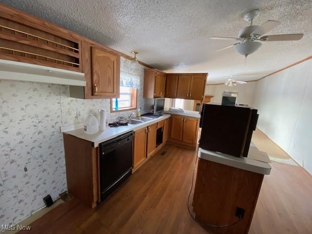 kitchen featuring a textured ceiling, ceiling fan, sink, dishwasher, and hardwood / wood-style floors