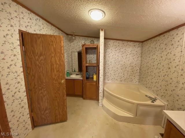 bathroom featuring crown molding, a bath, and a textured ceiling