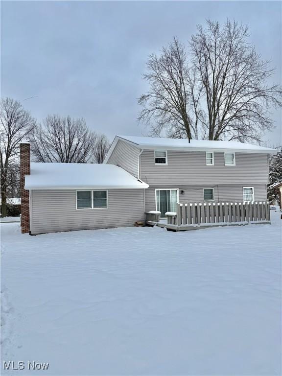 view of snow covered rear of property