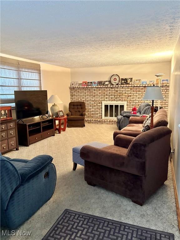 carpeted living room featuring a fireplace and a textured ceiling