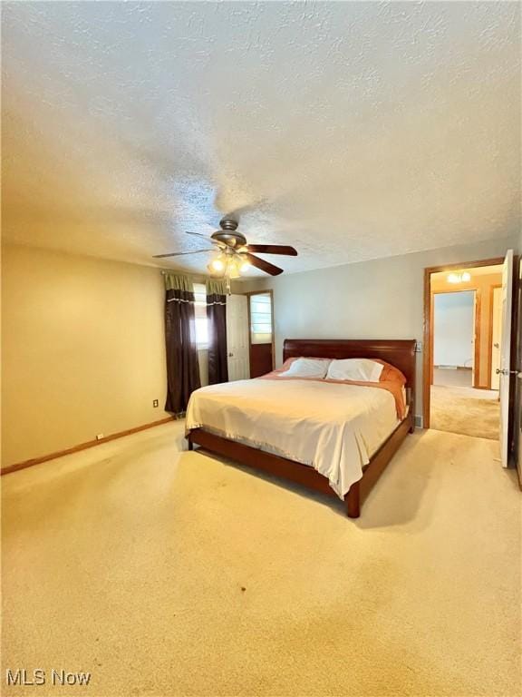 unfurnished bedroom with ceiling fan, light colored carpet, and a textured ceiling