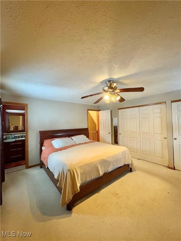 carpeted bedroom with ceiling fan, a closet, and a textured ceiling