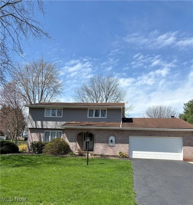 8777 Prancer Ave NW, North Canton, OH 44720 - traditional-style home featuring driveway, a front yard, a garage, and brick siding