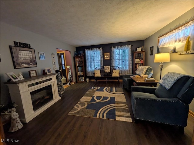 living room featuring a high end fireplace, a textured ceiling, and dark wood-type flooring