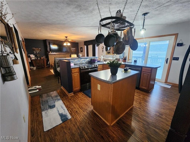 kitchen featuring black appliances, ceiling fan, dark hardwood / wood-style floors, a kitchen island, and kitchen peninsula