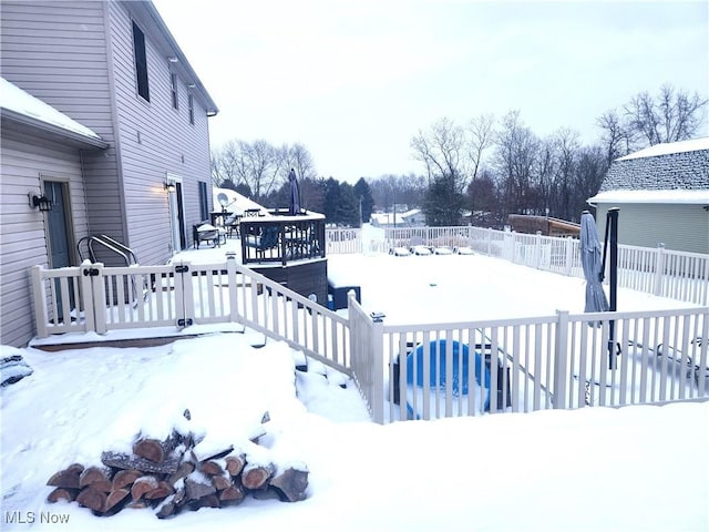 yard layered in snow with a deck