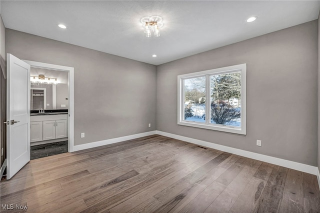 unfurnished bedroom with light hardwood / wood-style flooring and ensuite bath