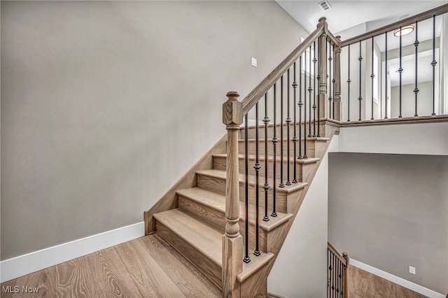 stairs featuring hardwood / wood-style floors