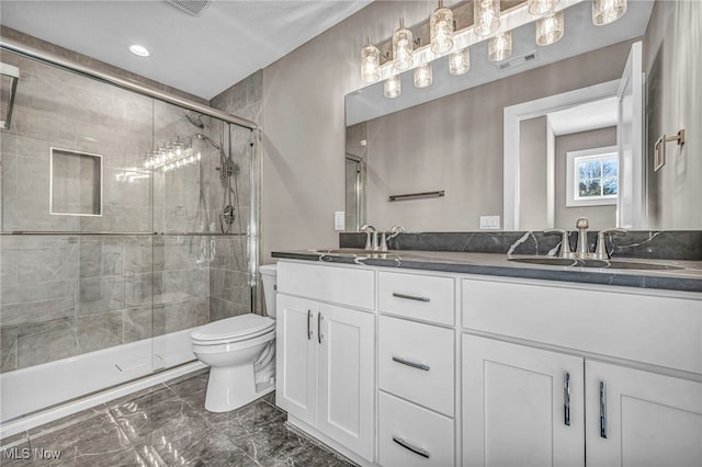 bathroom featuring vanity, toilet, and a shower with door