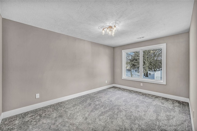 carpeted spare room featuring a textured ceiling