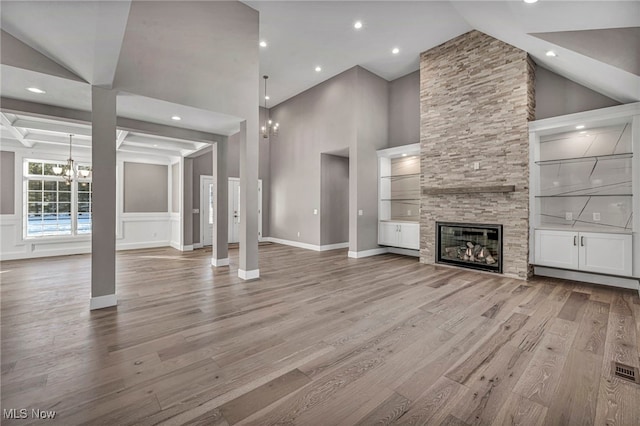 unfurnished living room featuring hardwood / wood-style floors, beam ceiling, and a fireplace