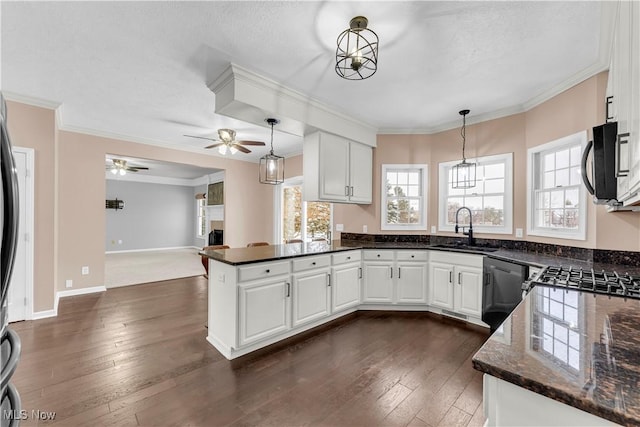 kitchen with kitchen peninsula, white cabinetry, sink, and hanging light fixtures