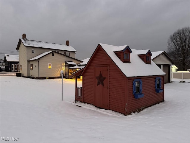 view of snow covered exterior with an outbuilding