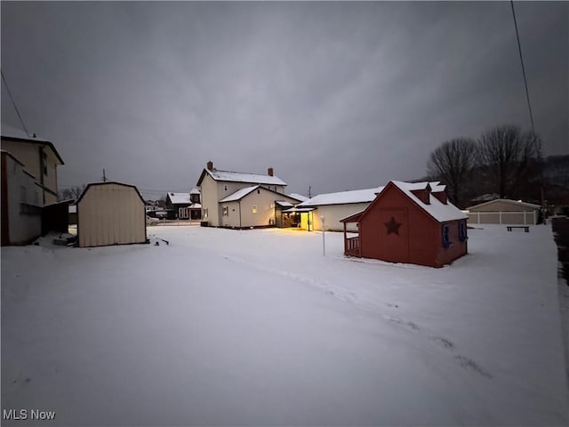 yard layered in snow with an outbuilding