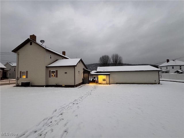 view of snow covered back of property