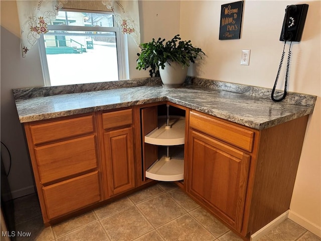 interior space with tile patterned floors and dark stone countertops