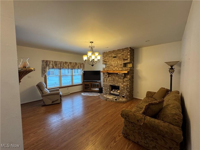 living room featuring a fireplace, hardwood / wood-style flooring, and an inviting chandelier