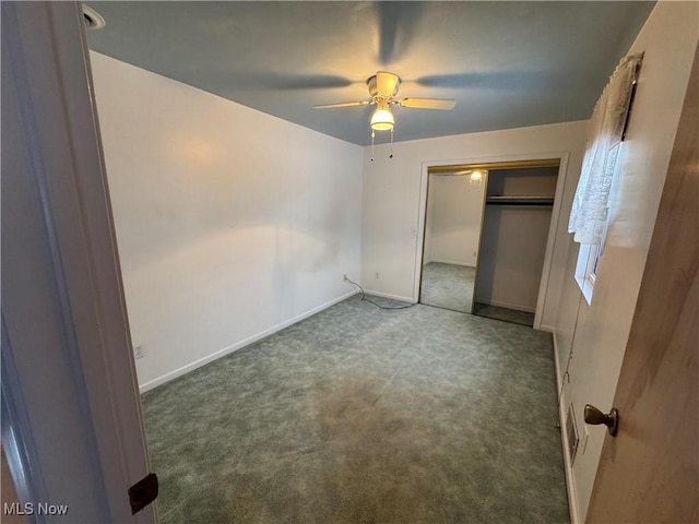 unfurnished bedroom with dark colored carpet, a closet, and ceiling fan