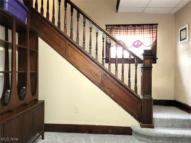 stairs featuring a paneled ceiling