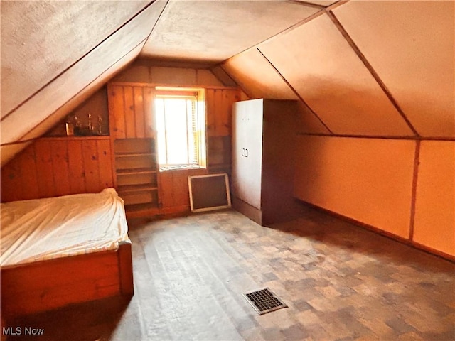 unfurnished bedroom featuring lofted ceiling and a textured ceiling