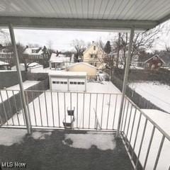 view of snow covered back of property