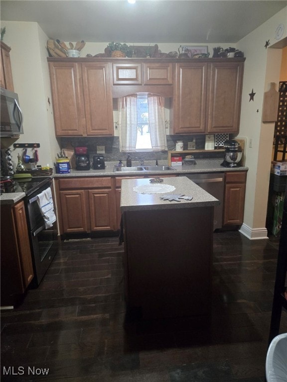 kitchen featuring dishwasher, a center island, dark wood-type flooring, sink, and black range with electric cooktop