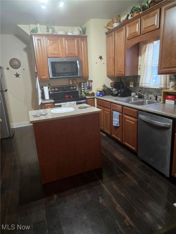 kitchen with tasteful backsplash, stainless steel appliances, dark wood-type flooring, sink, and a kitchen island