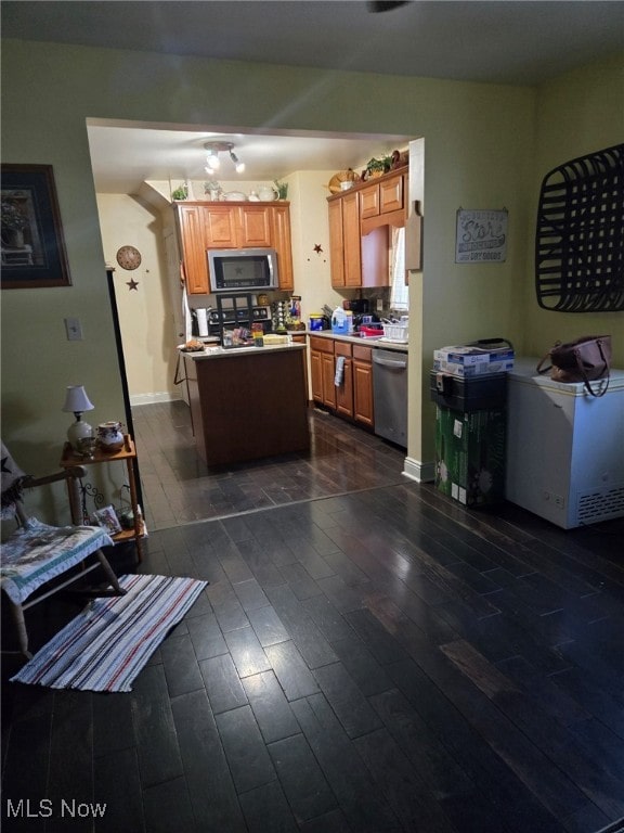 kitchen featuring a center island, stainless steel appliances, and dark hardwood / wood-style floors