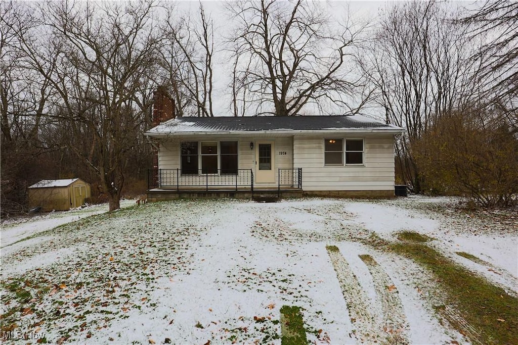 view of front of property with covered porch and a shed