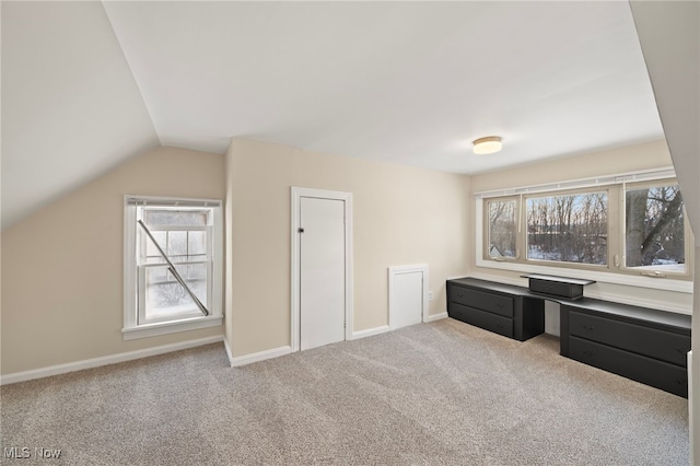 carpeted home office featuring a wealth of natural light and lofted ceiling