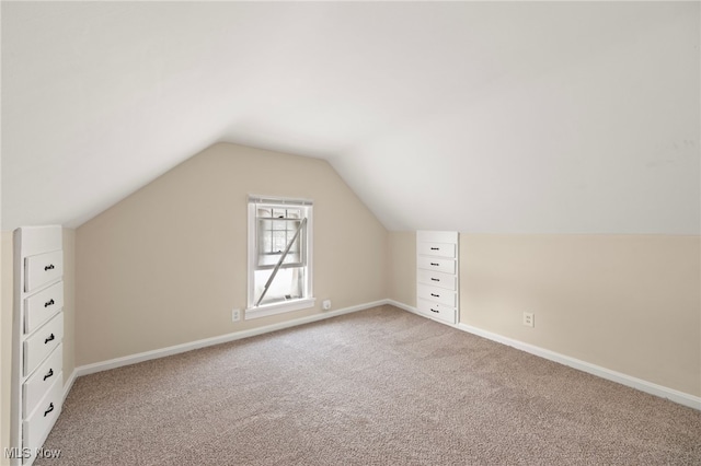 additional living space with carpet flooring and lofted ceiling