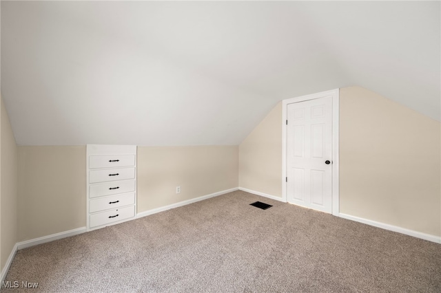 additional living space featuring carpet and vaulted ceiling