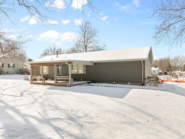 snow covered house with covered porch