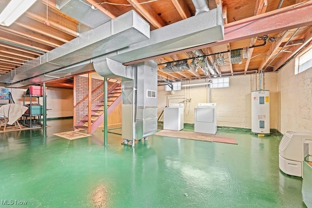 basement featuring water heater, heating unit, and washing machine and clothes dryer