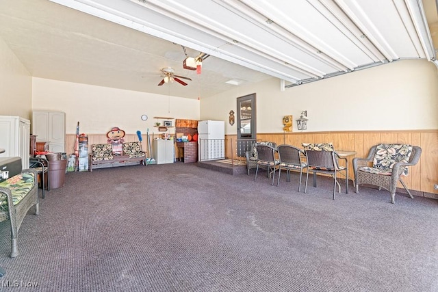 garage with white fridge, ceiling fan, and a garage door opener