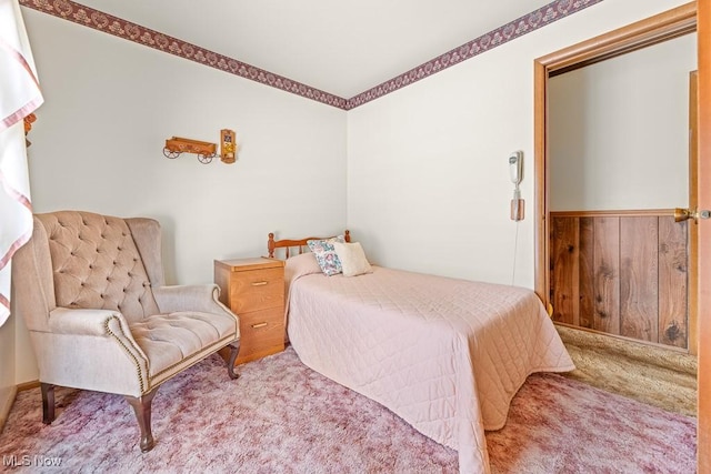 carpeted bedroom with wooden walls