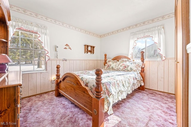 carpeted bedroom with wooden walls