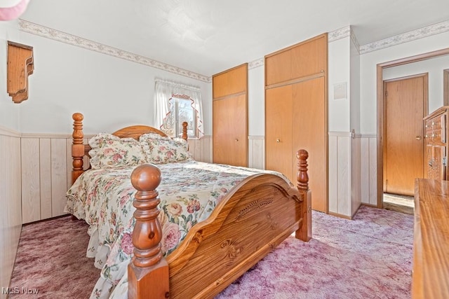 bedroom with light carpet and multiple closets