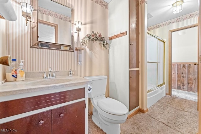 bathroom featuring toilet, vanity, and wooden walls