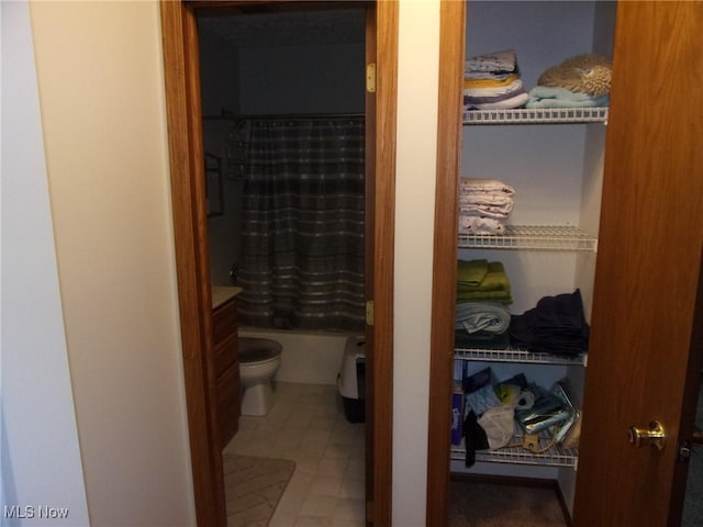 bathroom with shower / bath combination with curtain and toilet