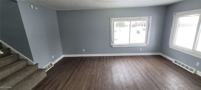 spare room with dark hardwood / wood-style flooring and a textured ceiling