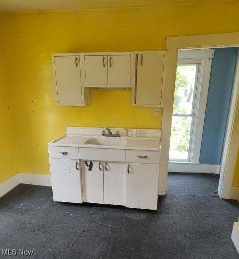 kitchen with a wealth of natural light, sink, and white cabinets